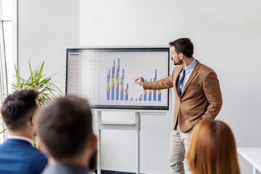 Executive presenting financials to a leadership team, representing an academic department facing a funding cliff