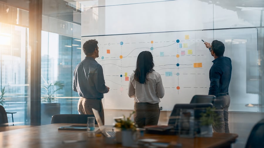 Two leaders mapping a new structure on a glass wall, representing the academic department restructuring gap
