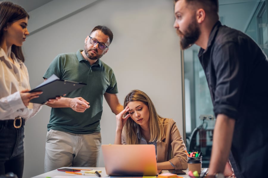 Leadership team frustrated by flat results on a laptop, representing a company stuck on a growth plateau